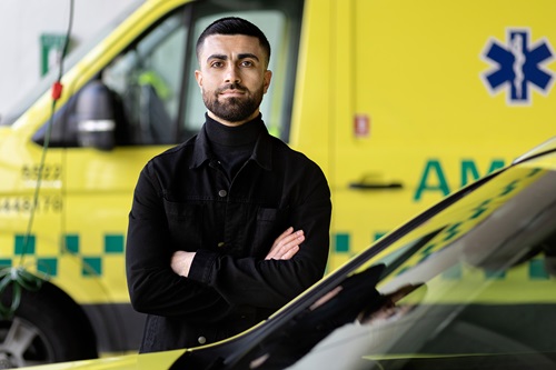 Karvan Shojaeipoor står foran en ambulance