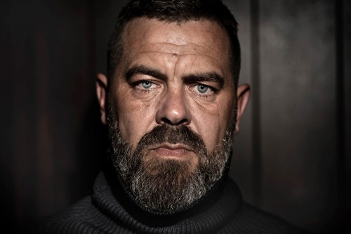 Kaspar Colling-Nielsen står foran en mørk væg