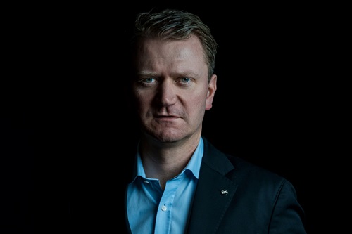 Kasper Fangel står foran en mørk baggrund