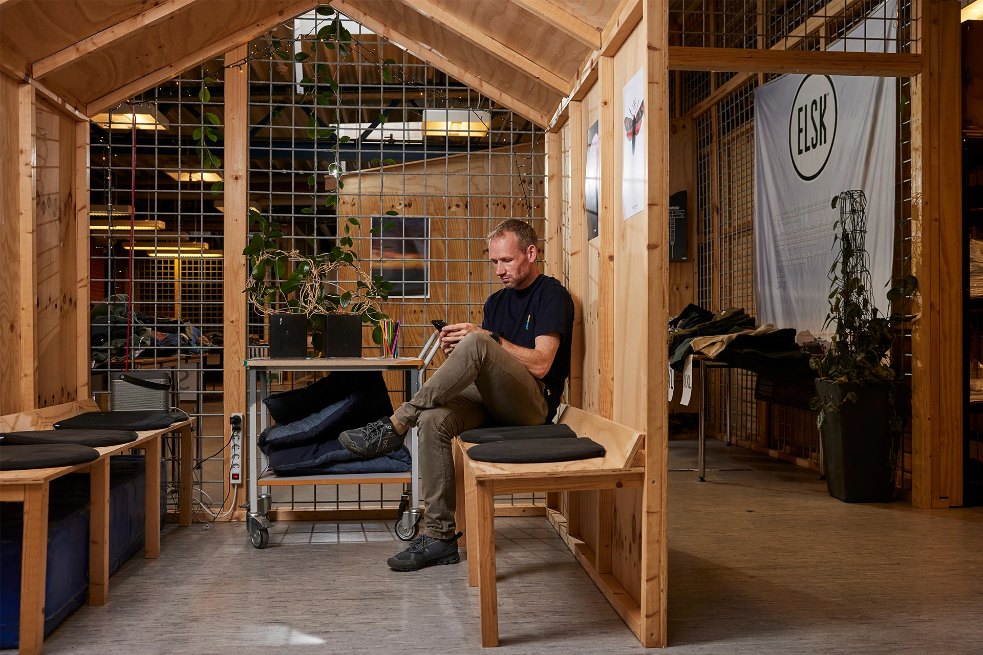 Lars Riis sidder på en bænk på ELSK's kontor med sin telefon