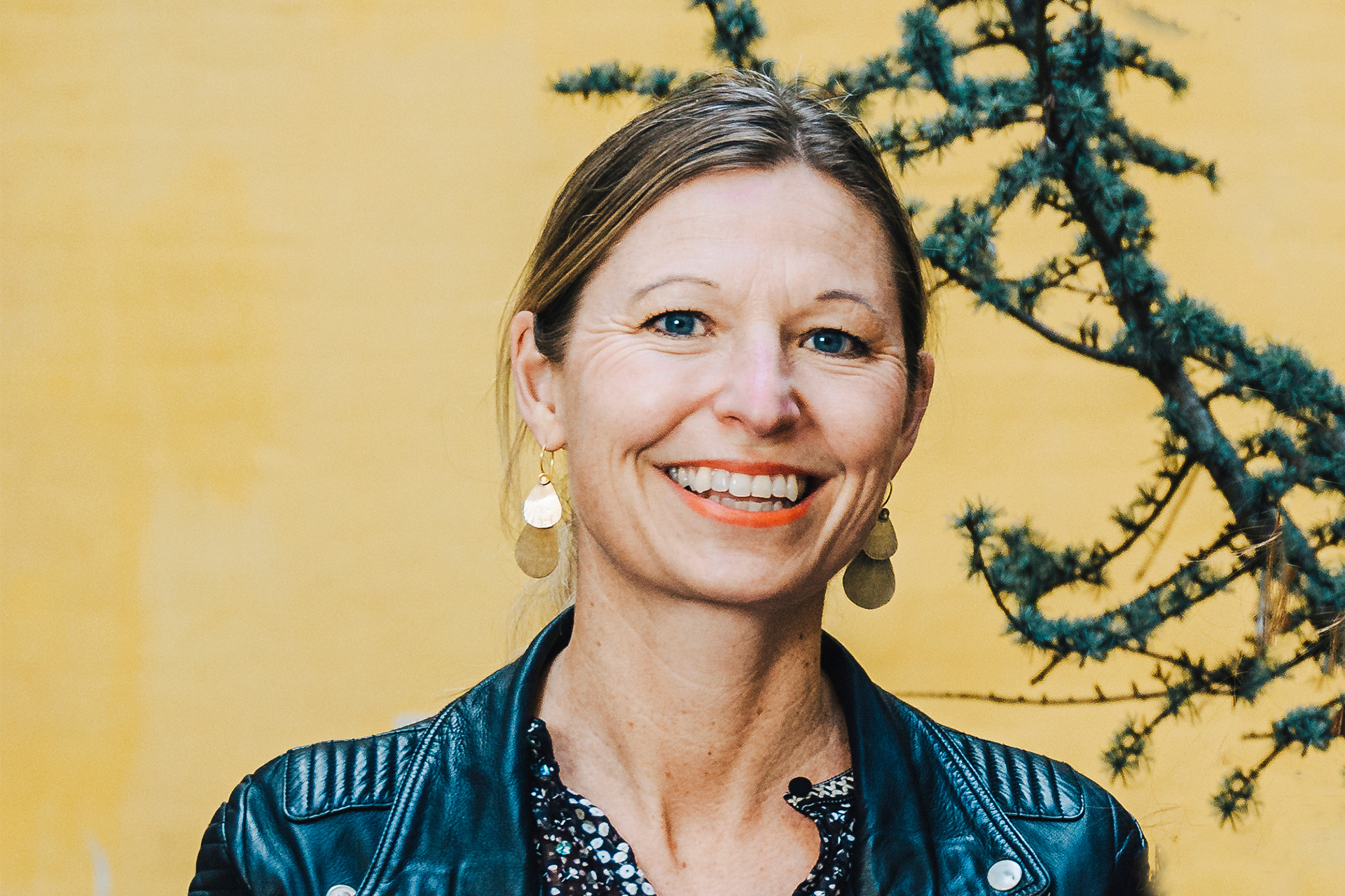 Louise Sparf smiler foran gul baggrund