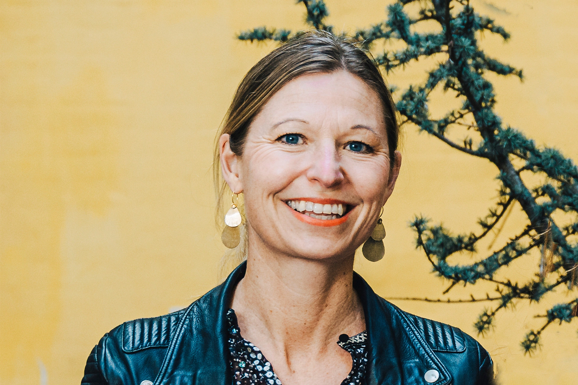 Louise Sparf smiler foran gul baggrund