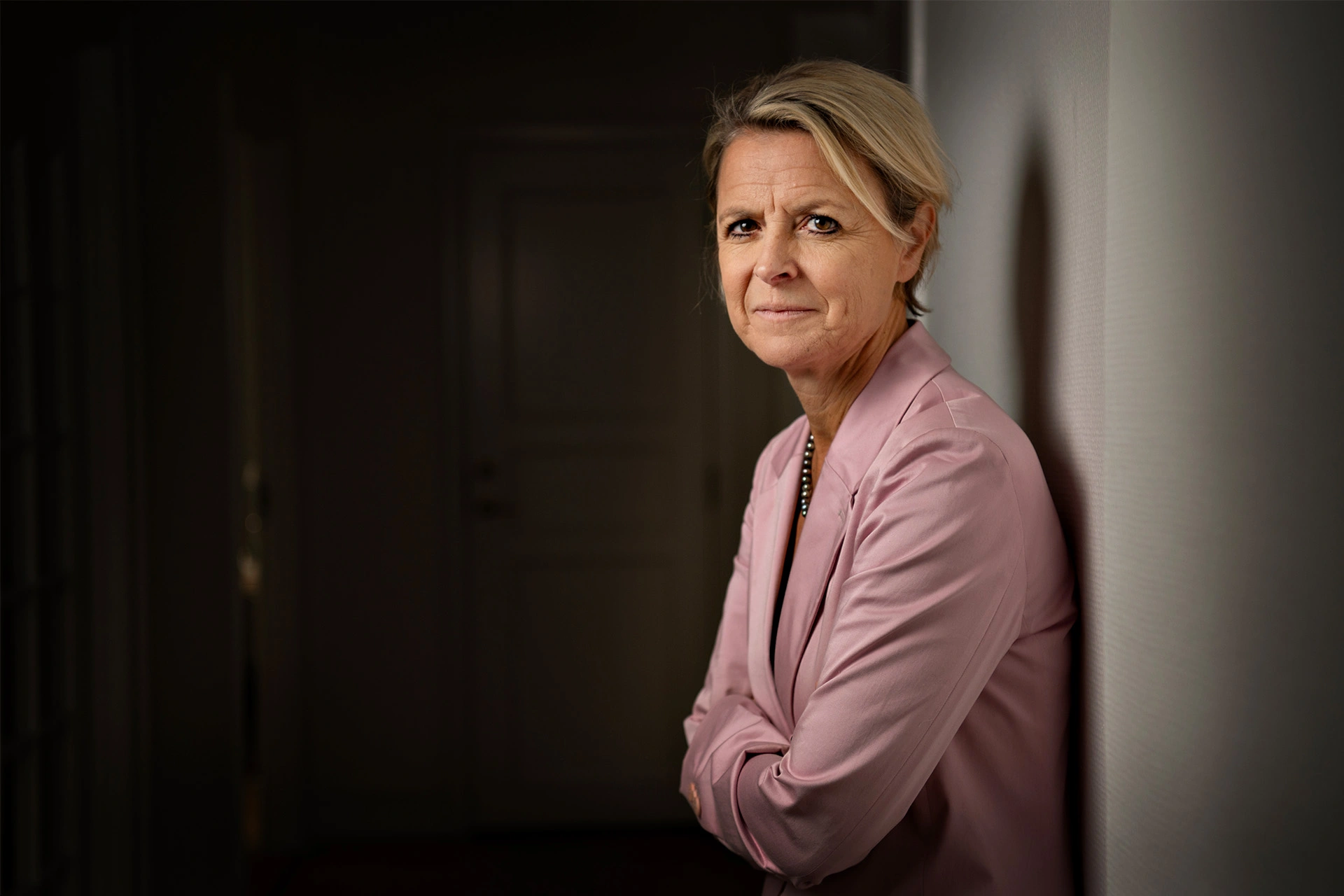 Lykke Friis står med ryggen mod en væg og ser ind i kameraret