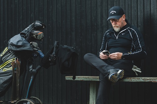 Maks Jørgensen sidder ved sin golftaske på en bænk