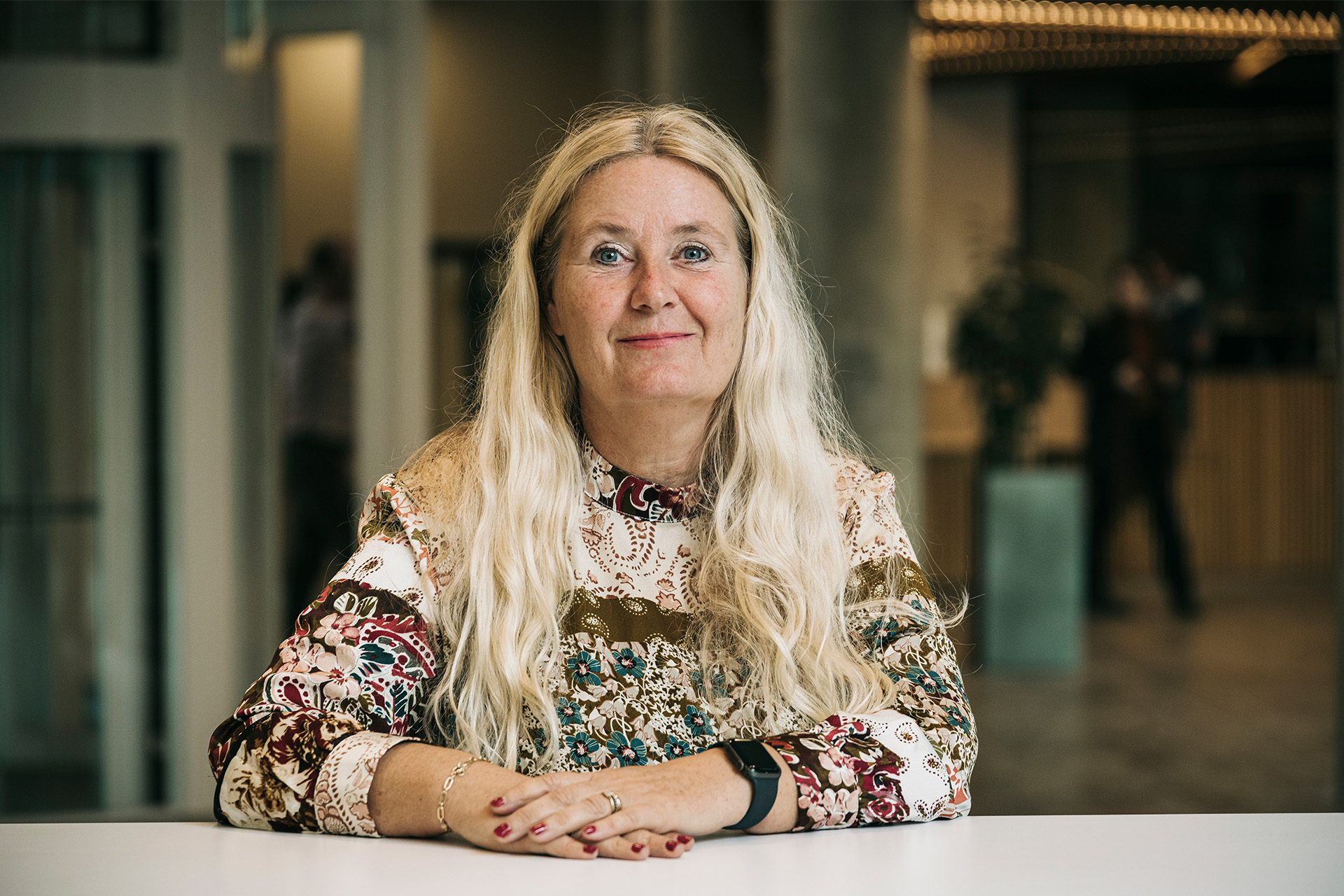 Marianne Foldberg Steffensen sidder ved et bord og smiler