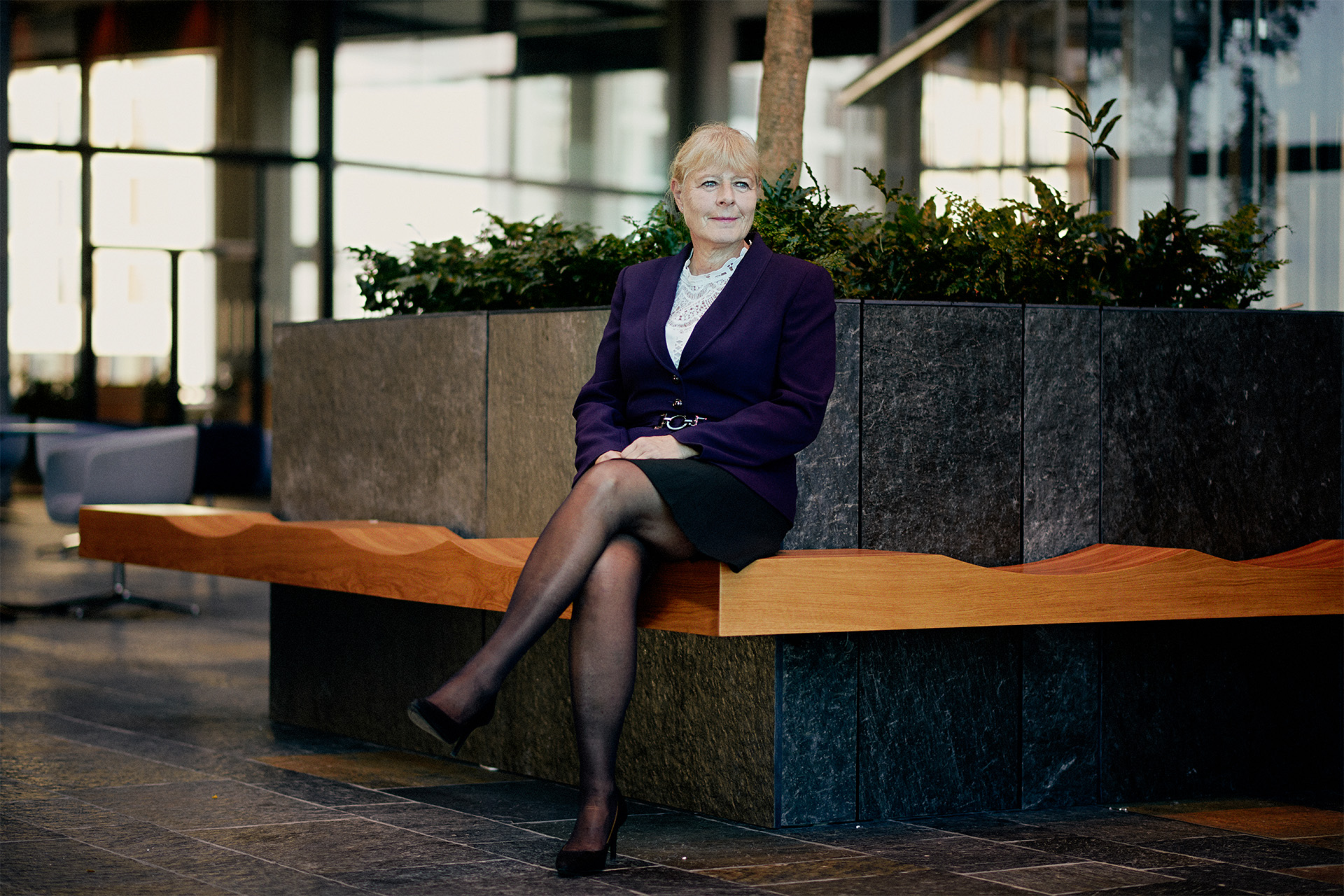 Marianne Kock sidder på en bænk på kontoret