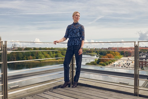 Erhvervsretoriker Mette Højen står på en balkon med udsigt over København