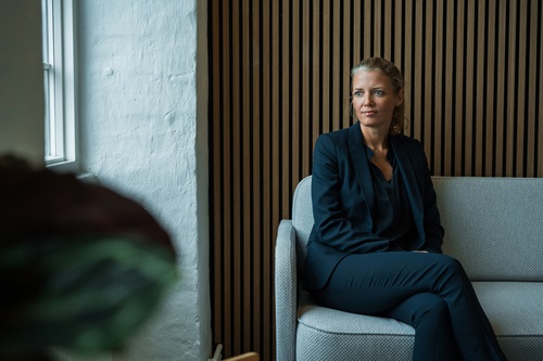 Mette Lykke sidder i en sofa på kontoret