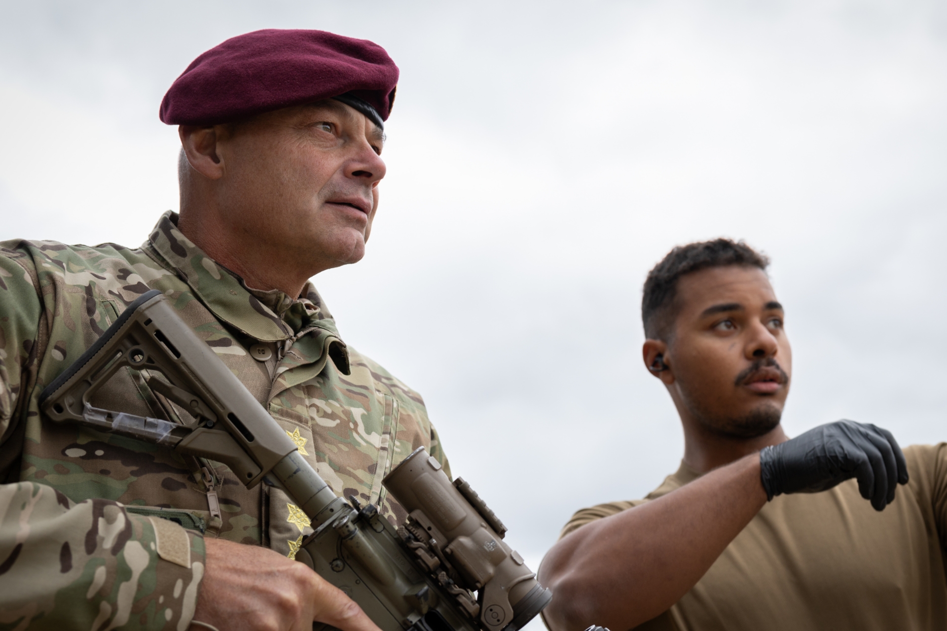 Michael Hyldgaard står med et gevær ved siden af en kollega