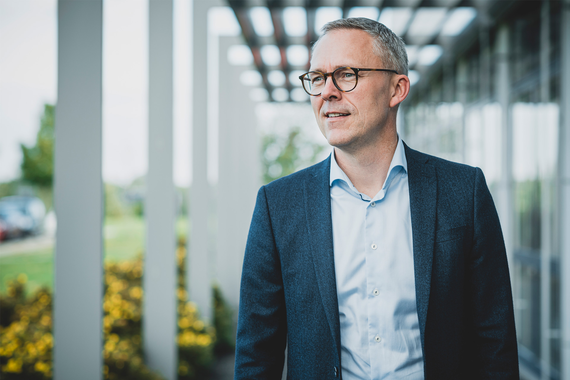 Michael Løve står på en sti ude foran en bygning