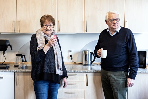 Ilse Møller og Lars Hansen står i Middelfart Sparekasses køkken og drikker kaffer
