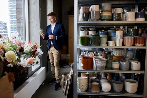 Mikkel Grene står med en potte på Søstrene Grenes lager