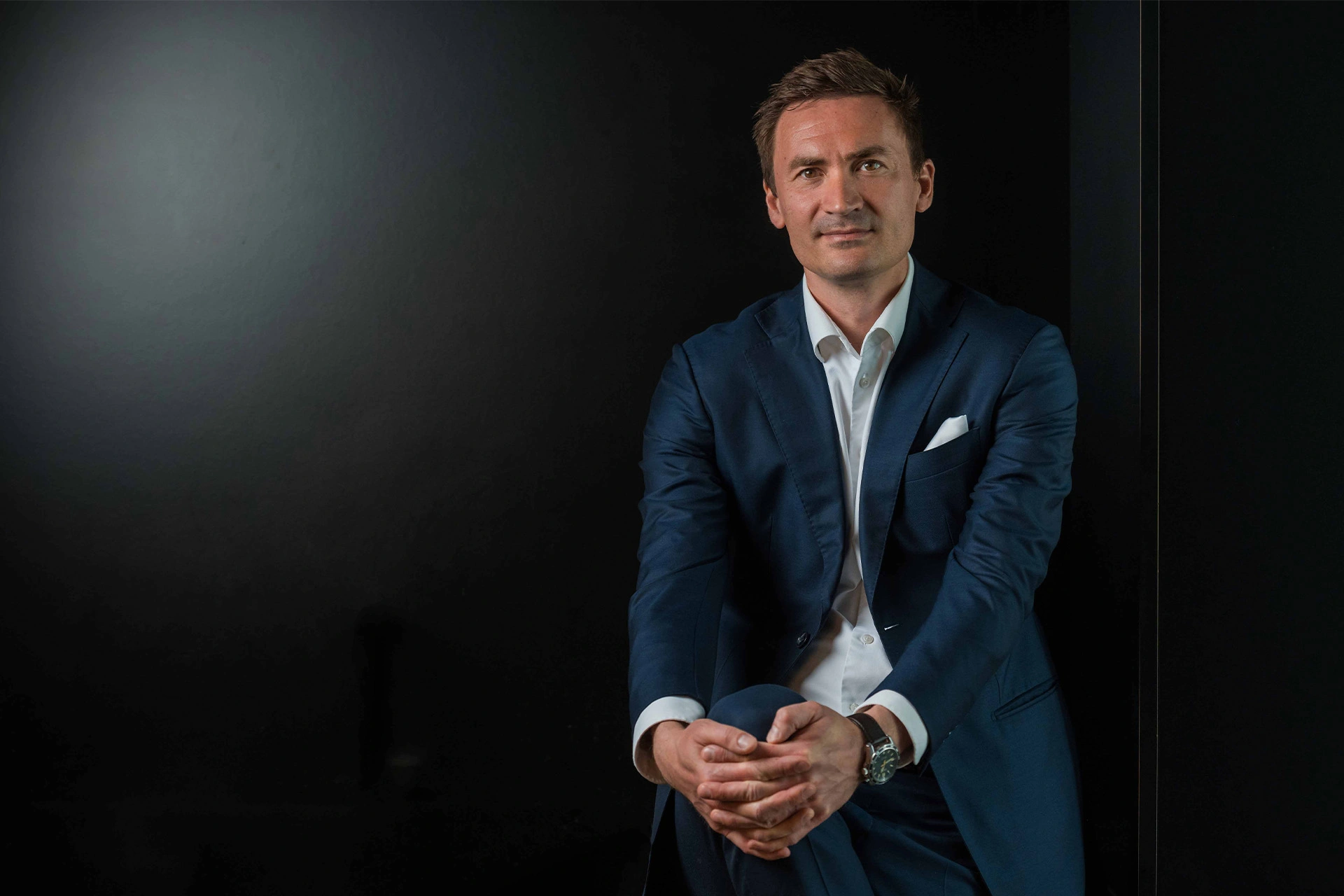 Mikkel Severin sidder foran en sort baggrund