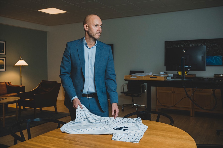 Nikolas Lyhne-Knudsen står på sit kontor med en baseball jersey