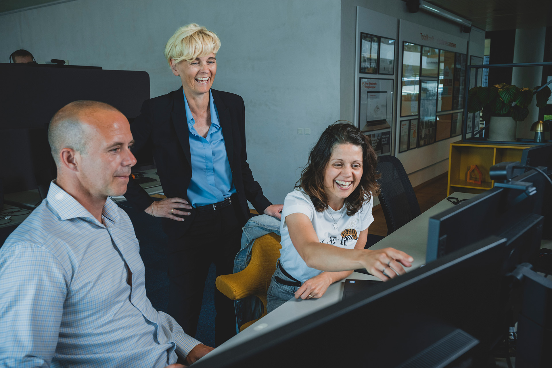 Pernille Sindby ser på en computer med to medarbejdere