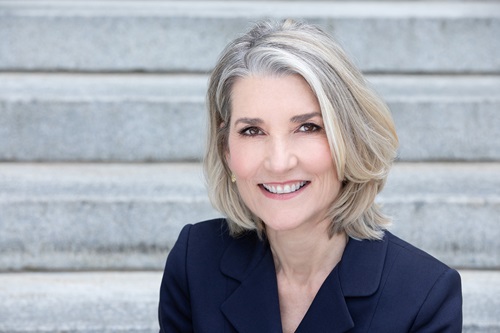 Amy Edmundson smiler og sidder på en trappe