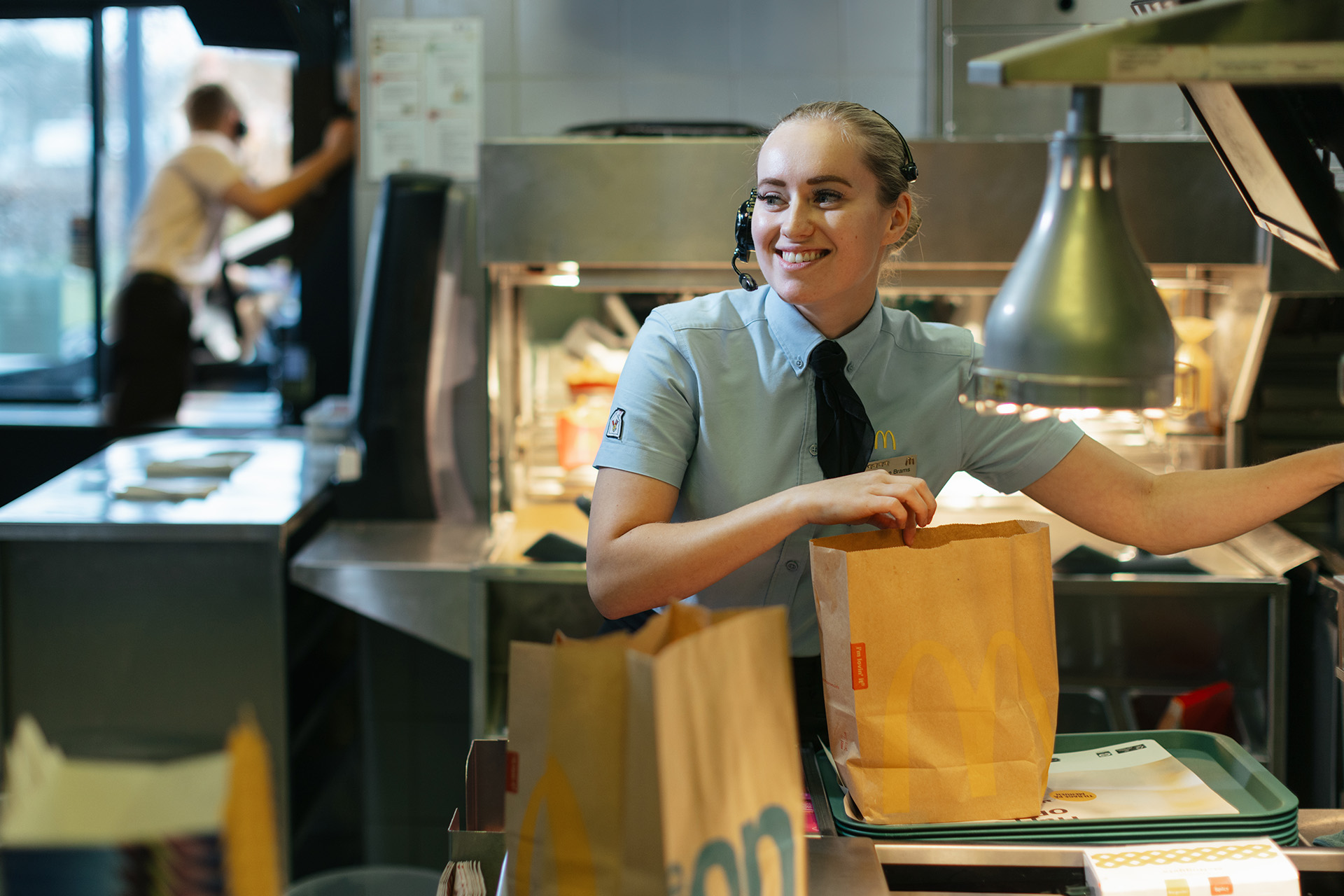 Rasmine Brams pakker en pose med mad i McDonalds