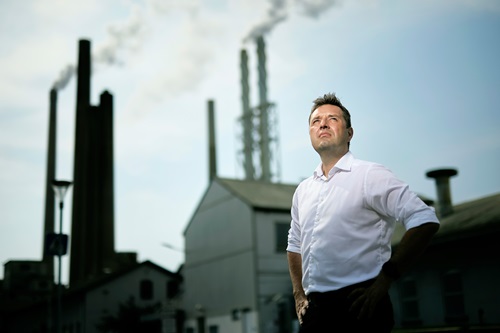 Søren Holm fotograferet i frøperspektivet foran Aalborg Portland bygning