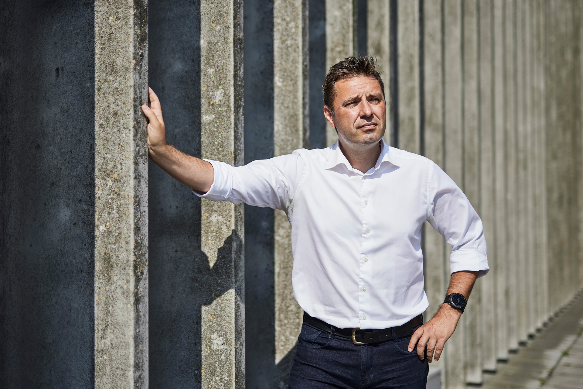 Søren Holm læner sig op af en port udenfor