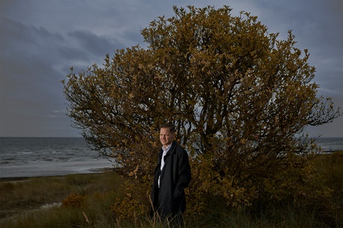Ulrik Drejsig står på en strand foran et træ