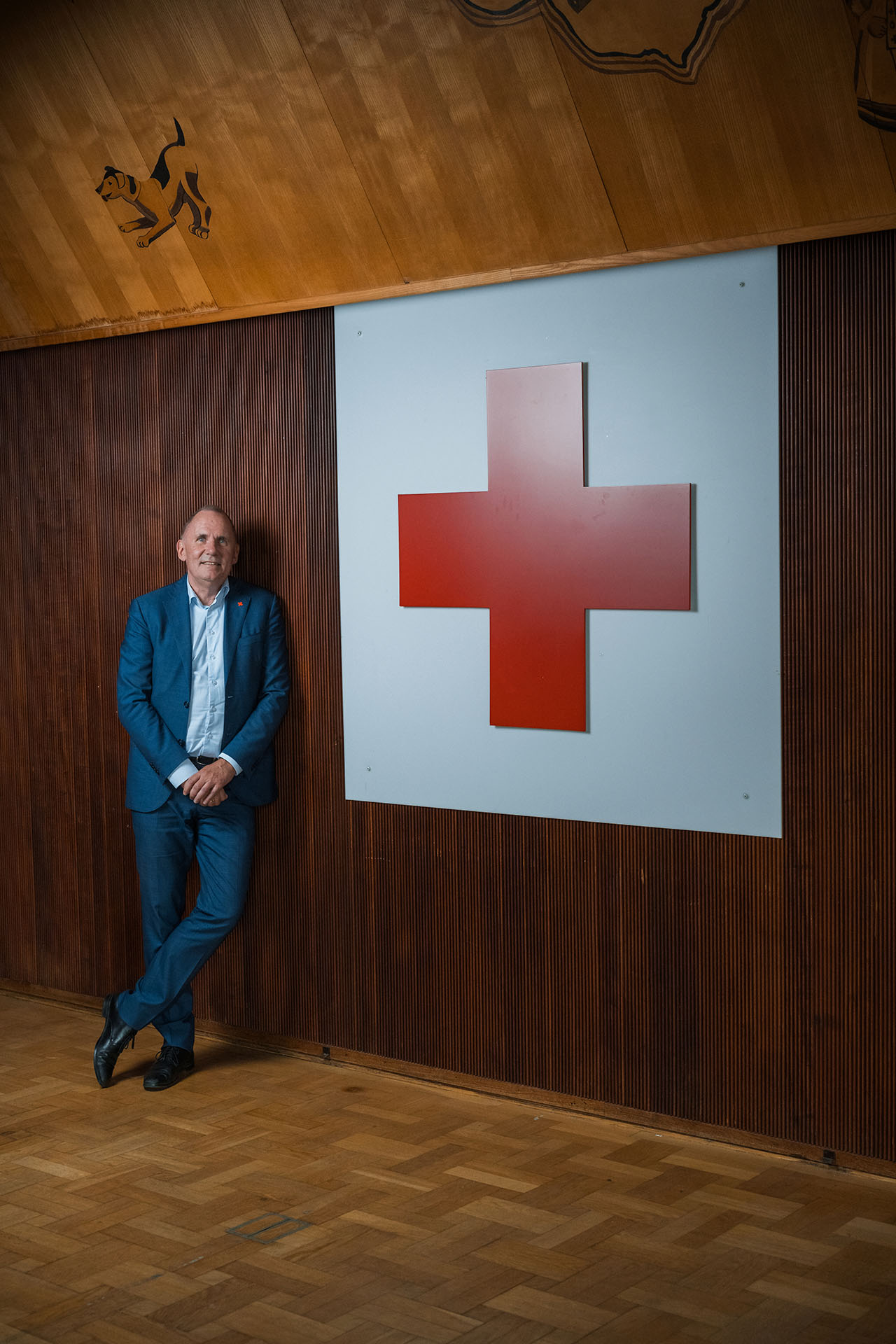 Anders Ladekarl står ved siden af et stort røde kors logo