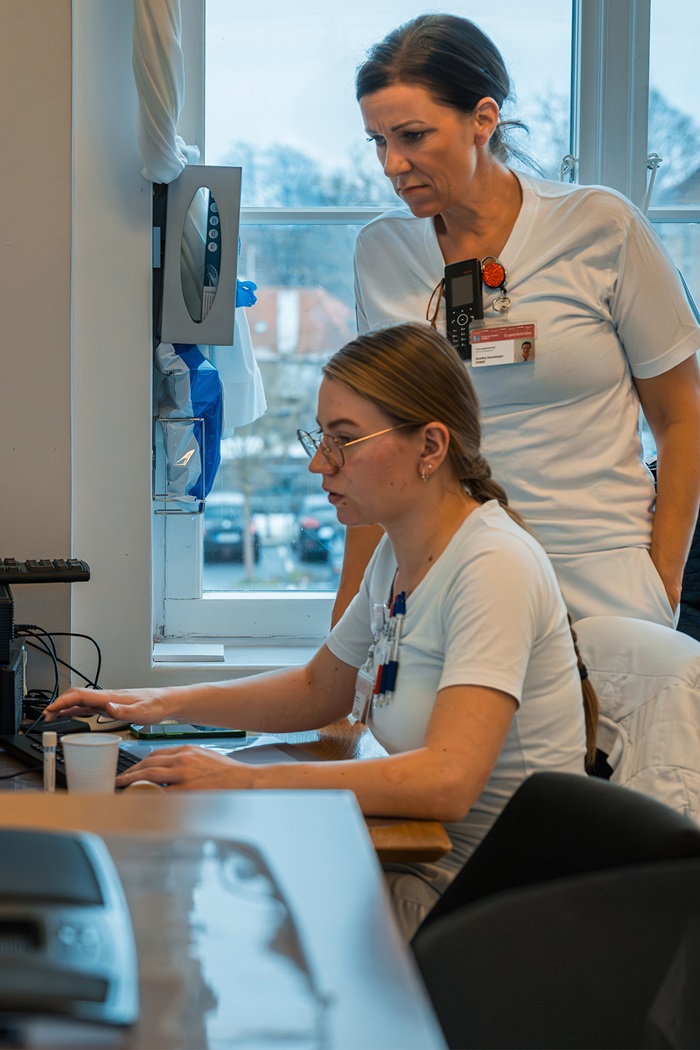 Anitha Danielsen og en kollega sidder ved en computer