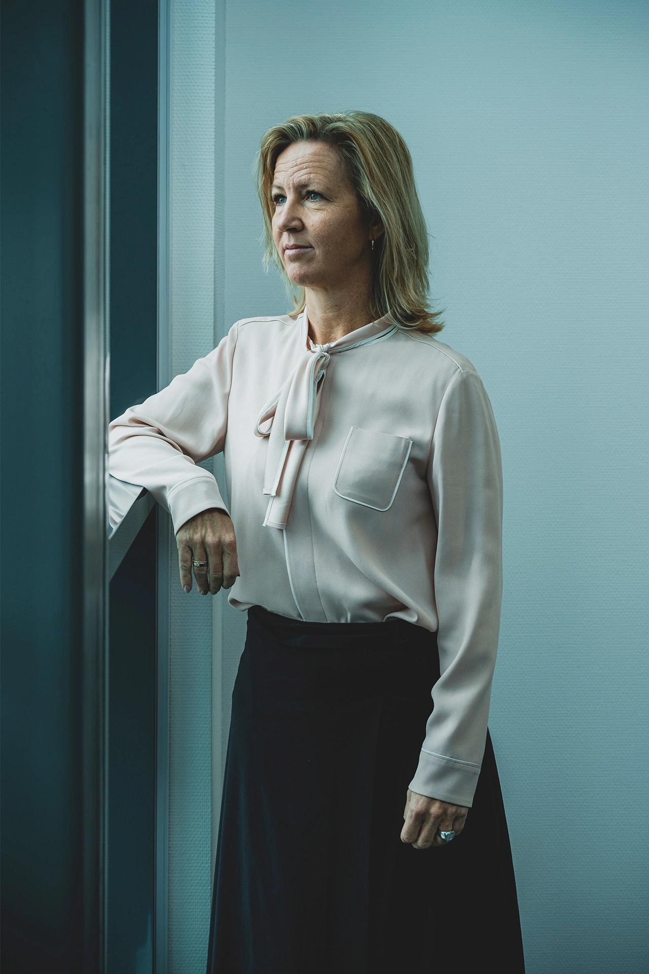 Britt Melby står og ser ud af et vindue