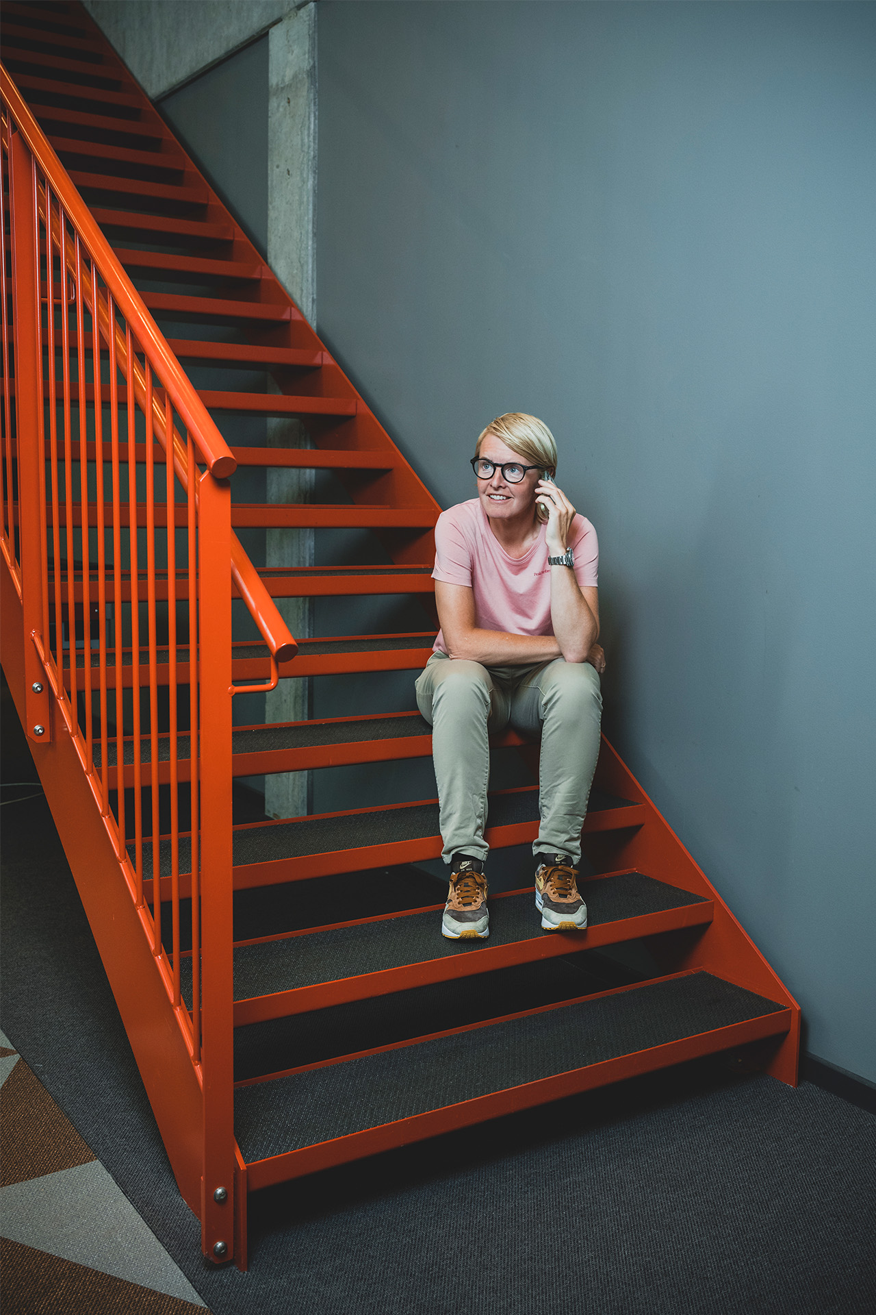 Camilla Andersen sidder på nogle trapper og snakker i telefon