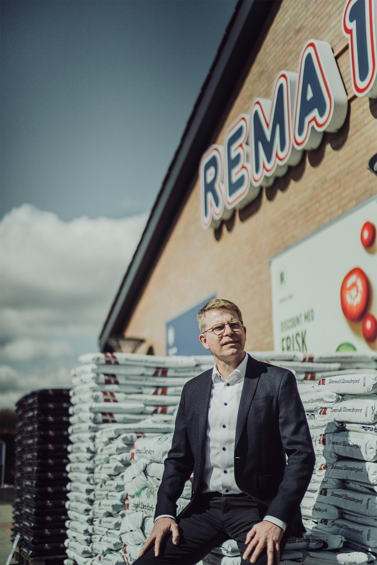 Henrik Burkdal sidder ude foran en REMA 1000 butik