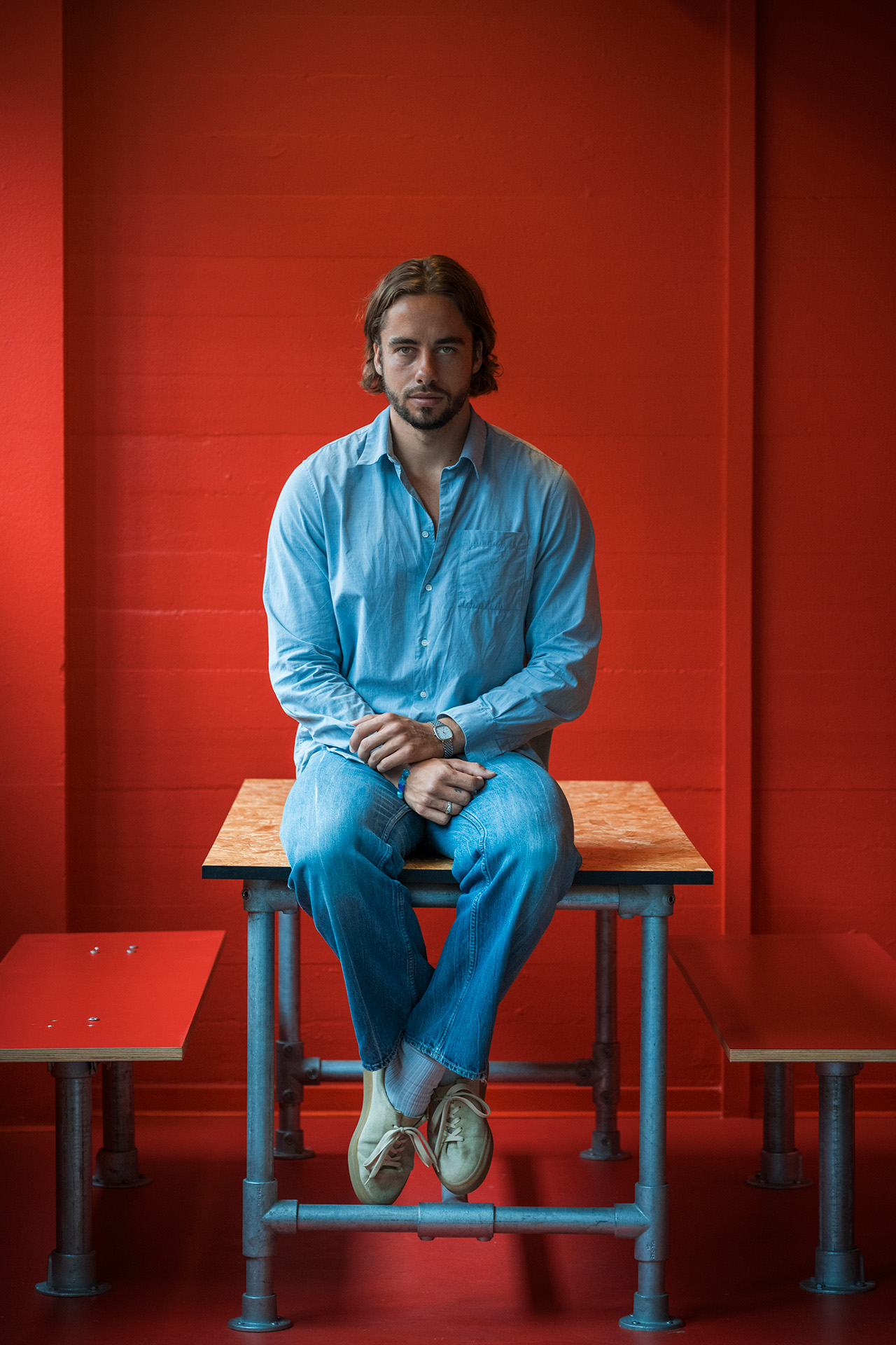 Jesper Thiel Thomsen sidder på et bord i et rødt lokale