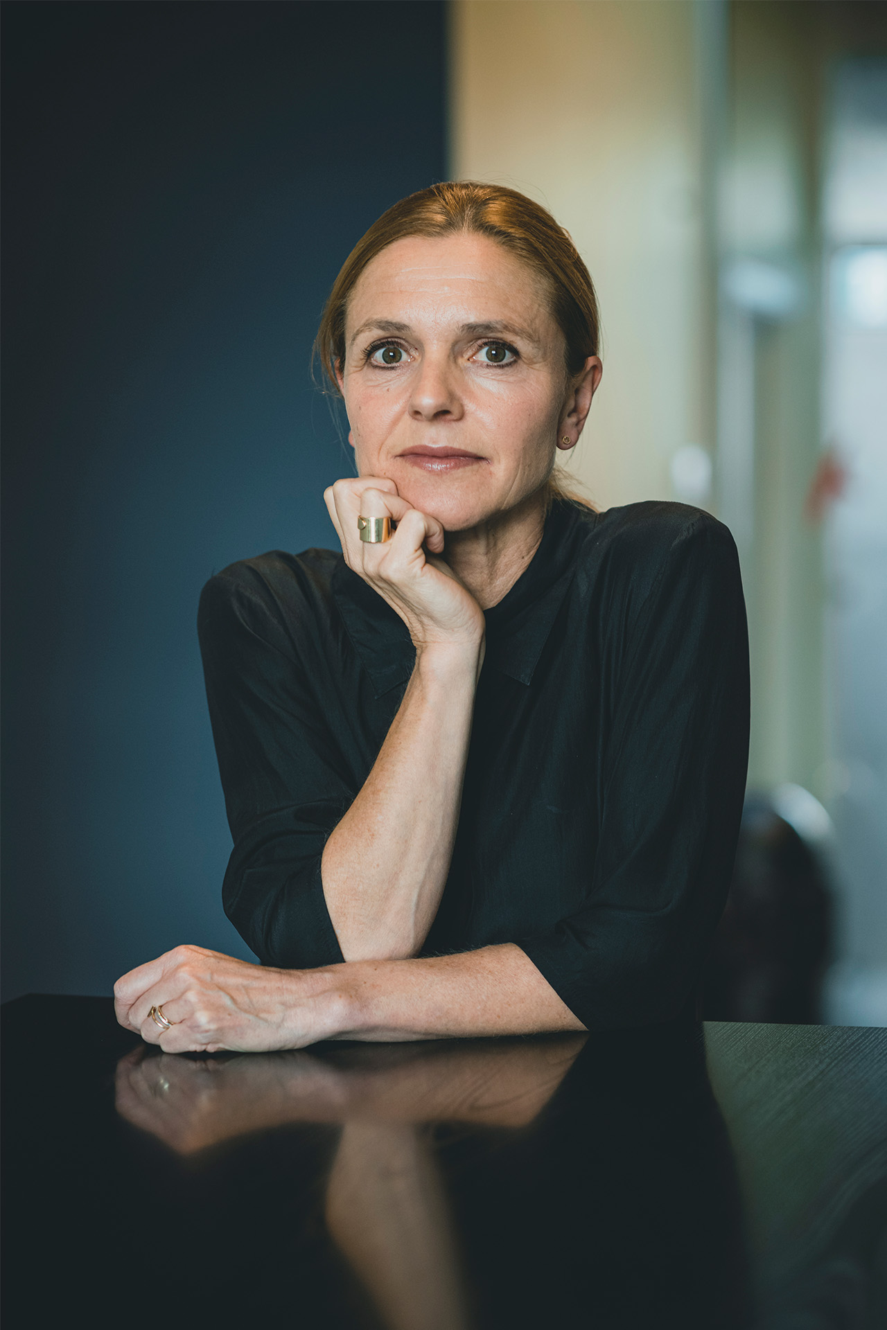 Portrætbillede af Lotte Juul Fogsgaard, der sidder ved et bord