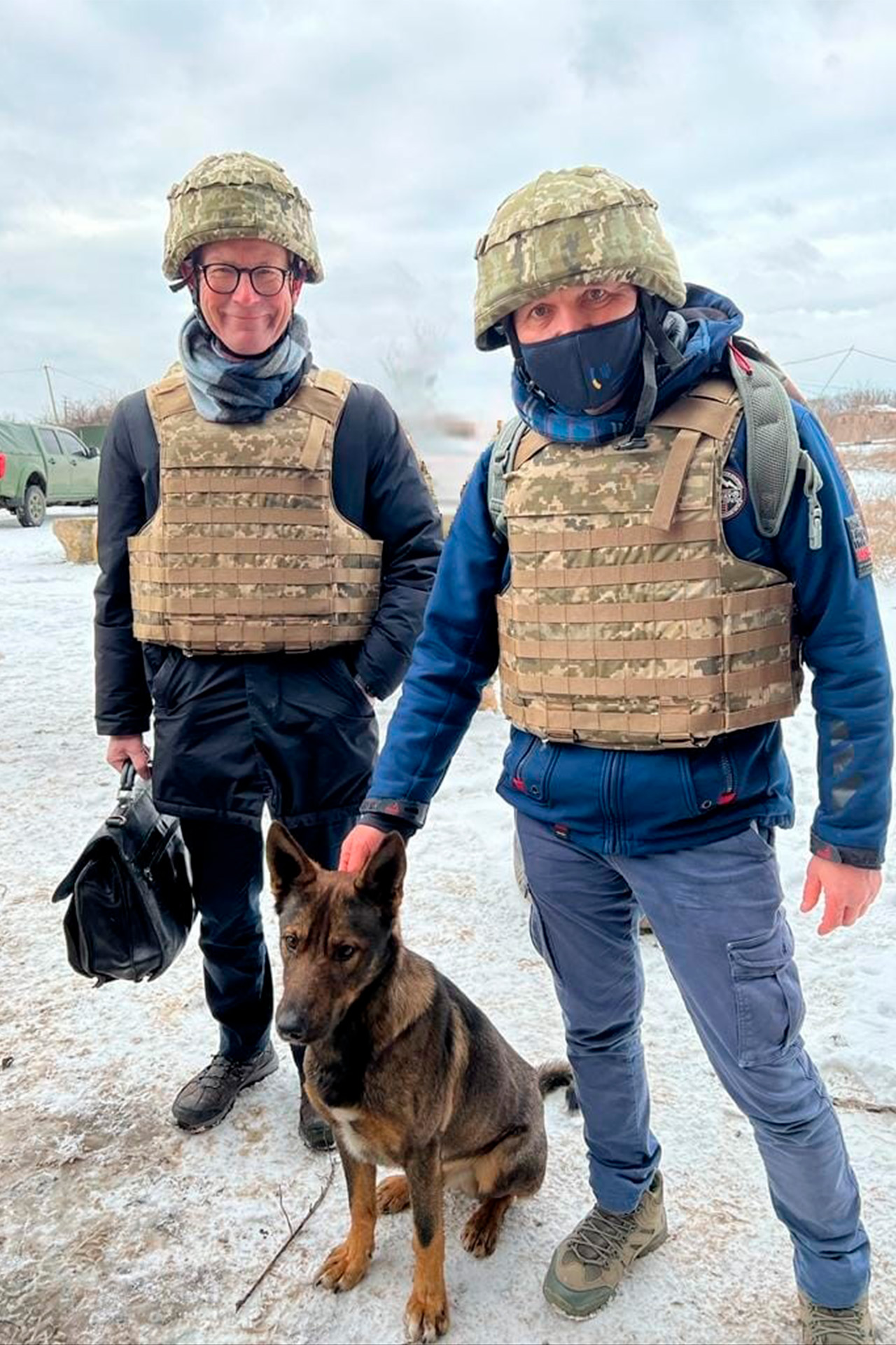 Ole Egberg Mikkelsen med skudsikker vest og hjelm ved siden af sikkerhedsfolk