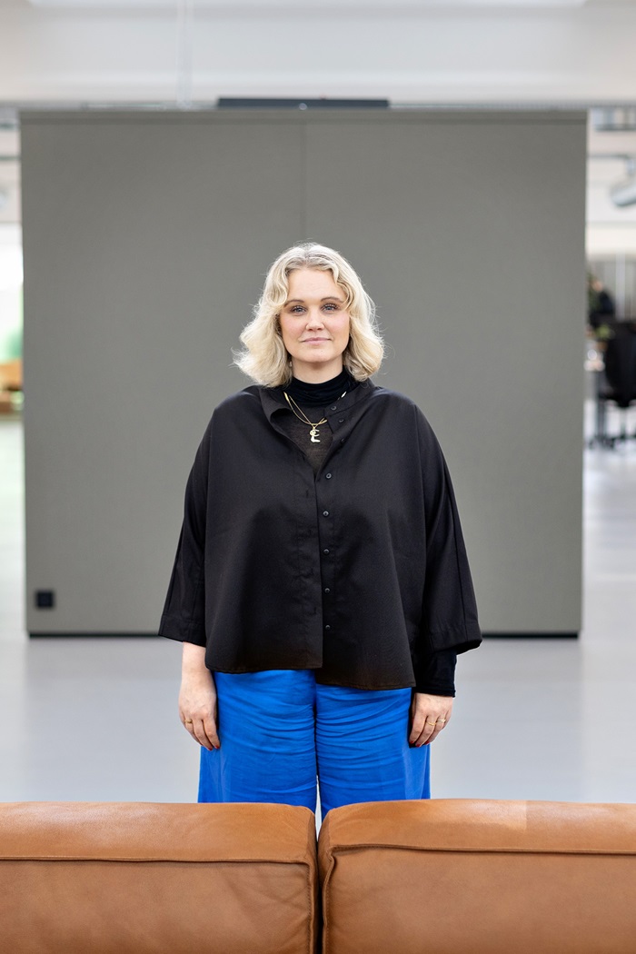 Sara Green står midt i et lokale i virksomheden Pico Publish