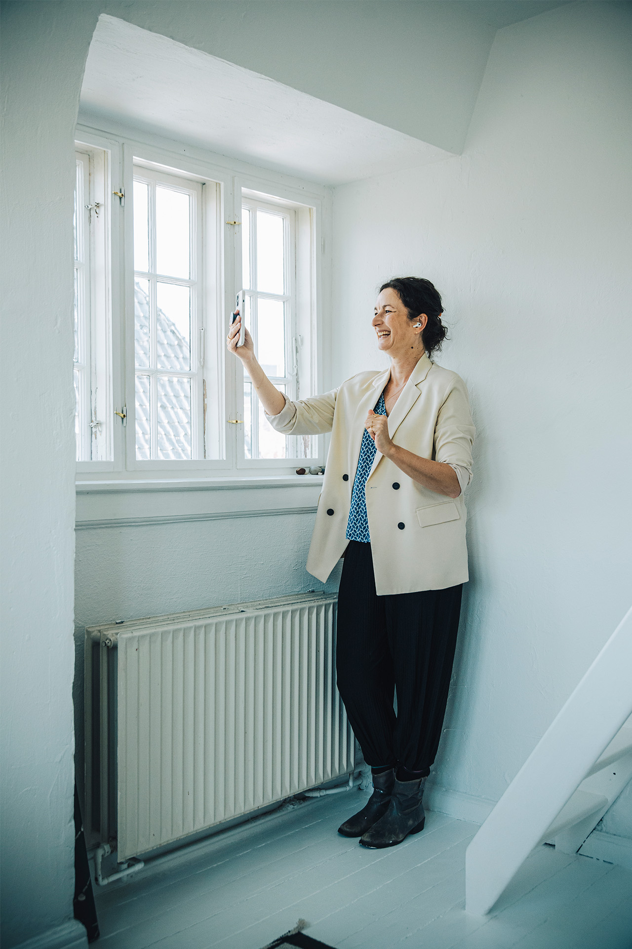 Rie Helmer i online-møde på mobilen på hjemmekontoret