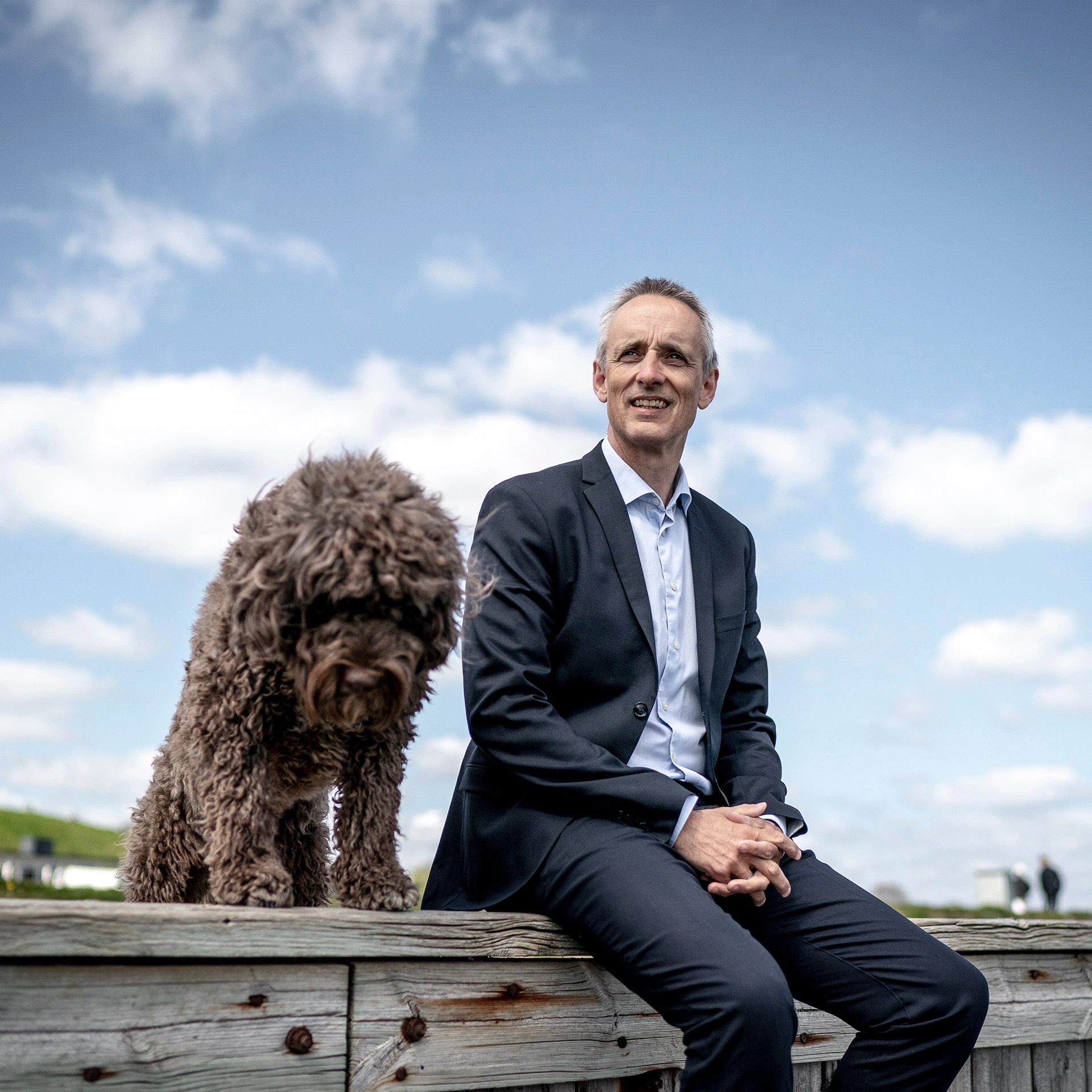 Anders Dons sidder ved vandet med sin hund