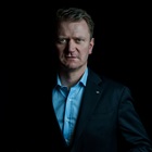 Kasper Fangel står foran en mørk baggrund