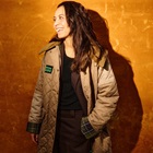 Rebecca Holmberg Jensen griner og står foran en orange væg