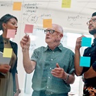 Ældre medarbejder står blandt yngre kolleger