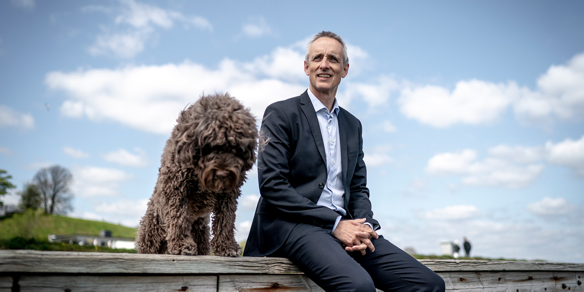 Anders Dons sidder ved vandet med sin hund