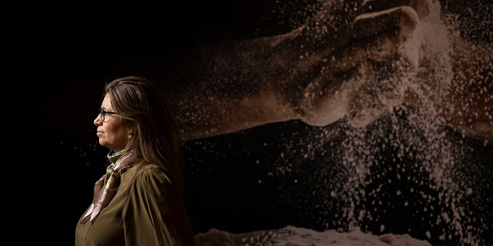 Anette Kalle står foran stor plakatbaggrund med bagerhænder