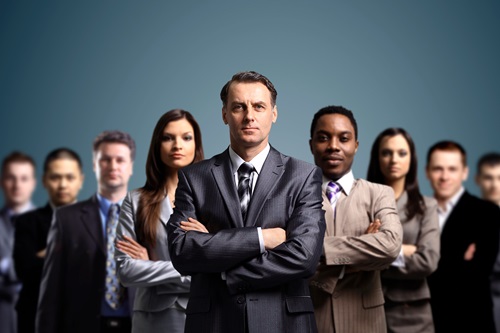 Mennesker i jakkesæt som står med armene lagt over kors