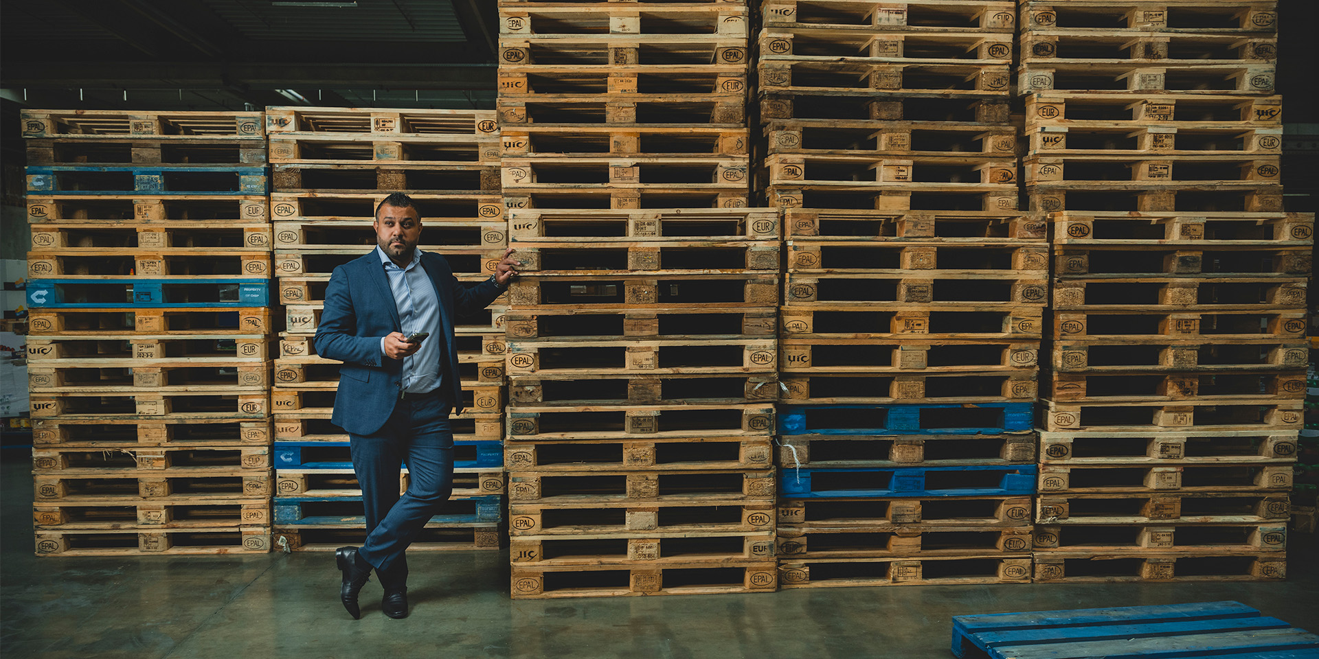 Braw Bakir på et Netto lager ved siden af en bunke paller