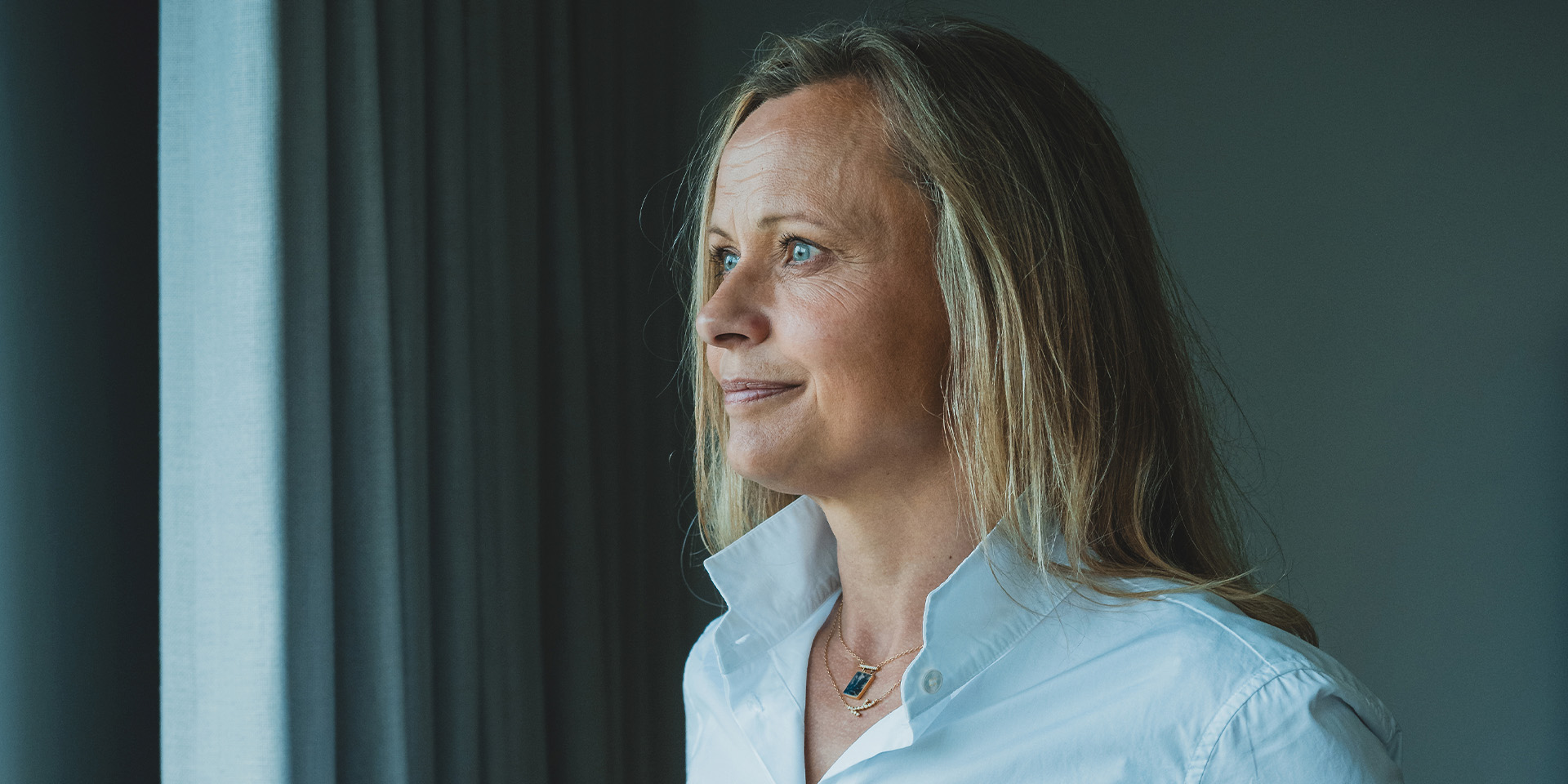 Britta Korre Stenholt kigger på gardiner