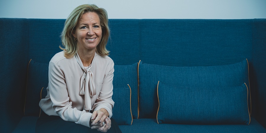 Britt Melby sidder på en blå sofa