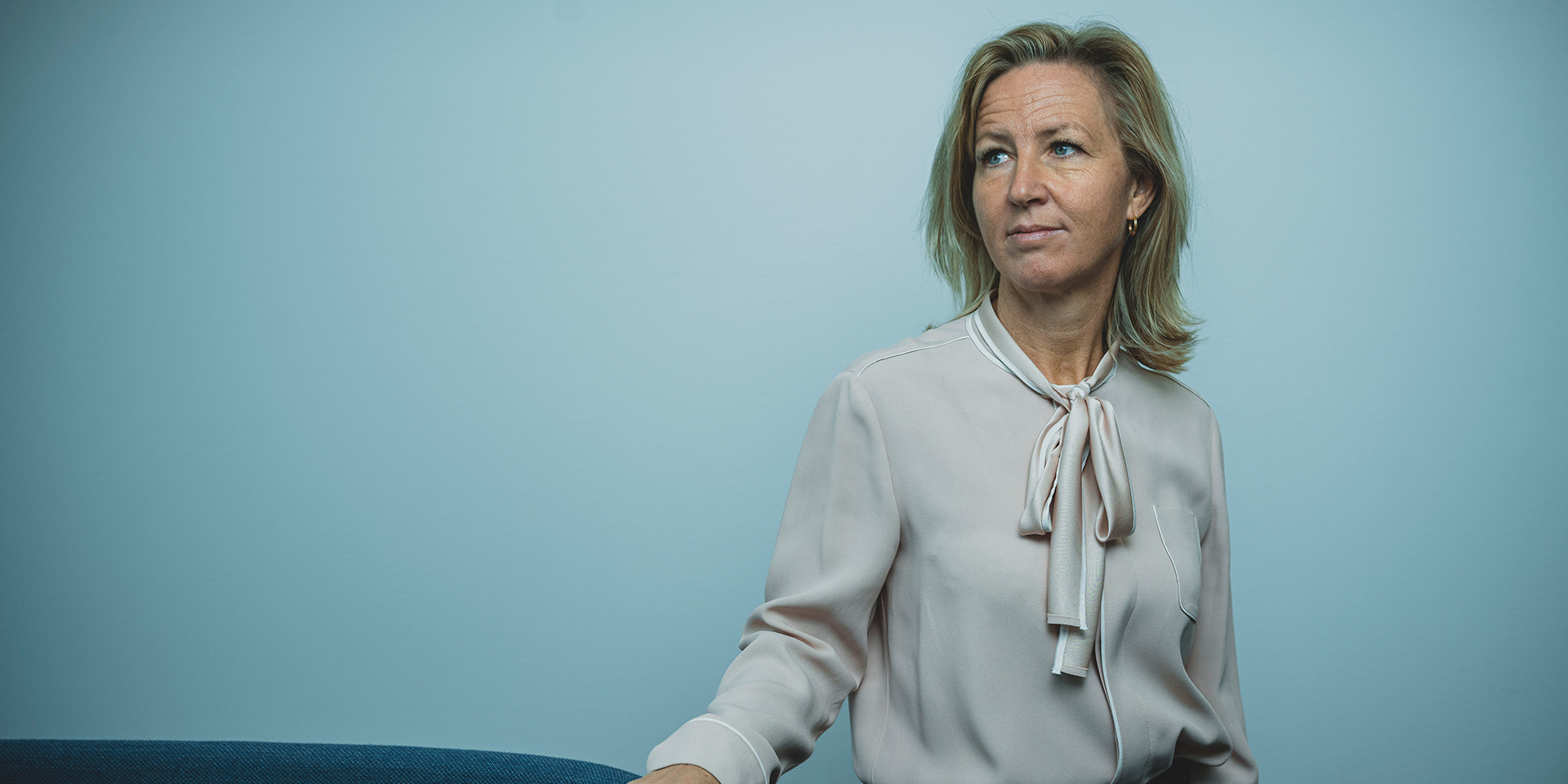 Britt Melby står foran en blå væg