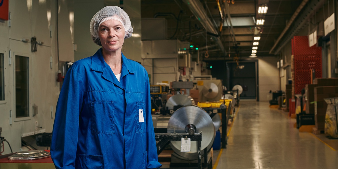 Camilla Haustrup Hermansen iført blå kittel på Plus Pack fabrikken