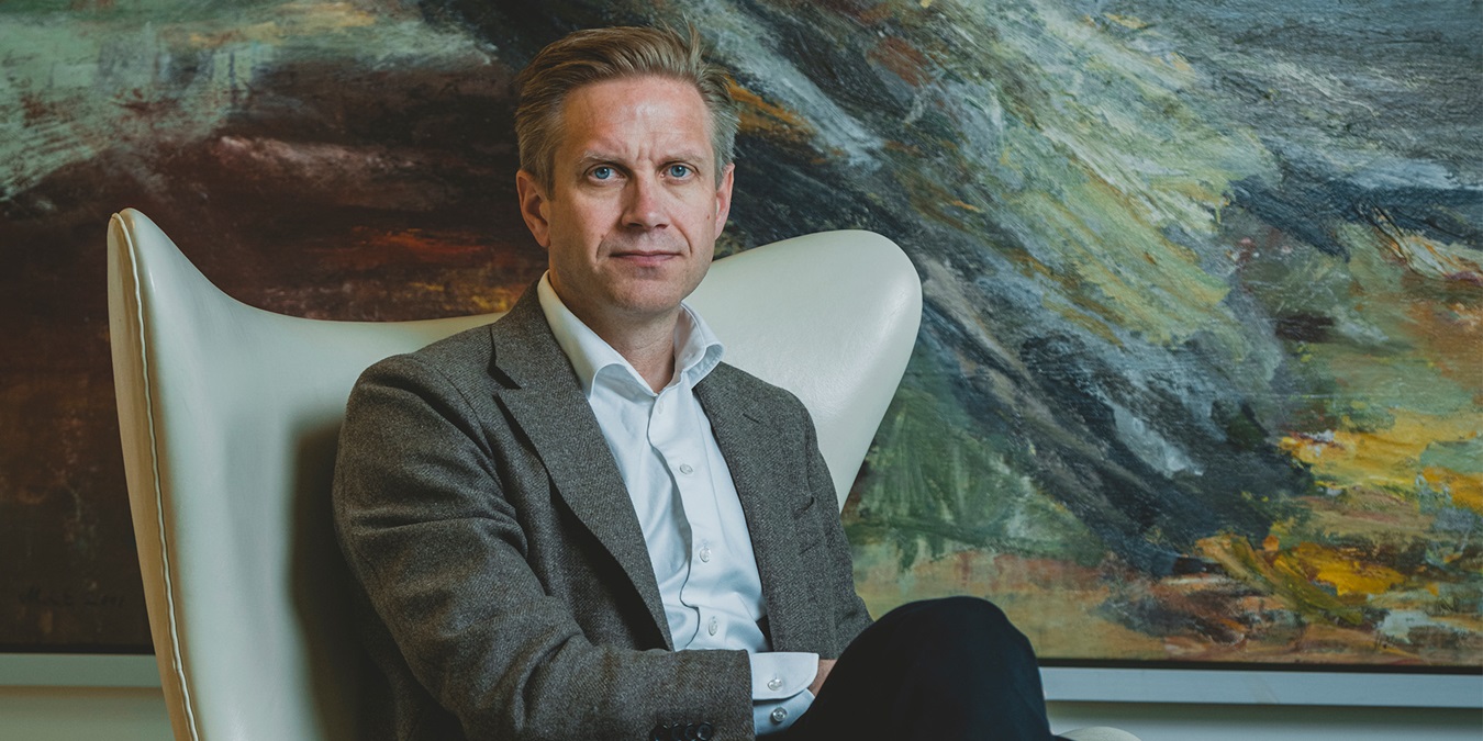 Portrætbillede af Christian Jensby foran et maleri