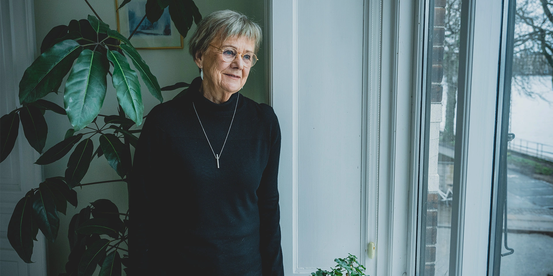 Else Relster står ved en vindueskam og skuer ud i horisonten