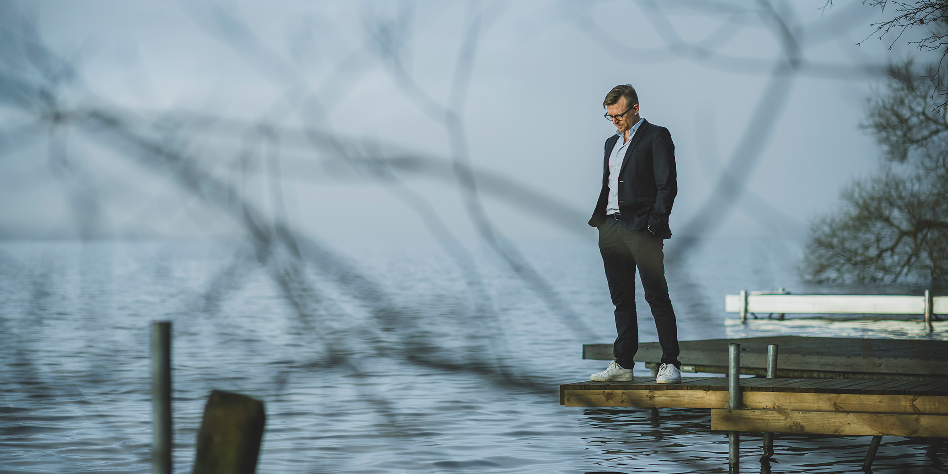 Eske Gunge står på en badebro og ser ned i vandet