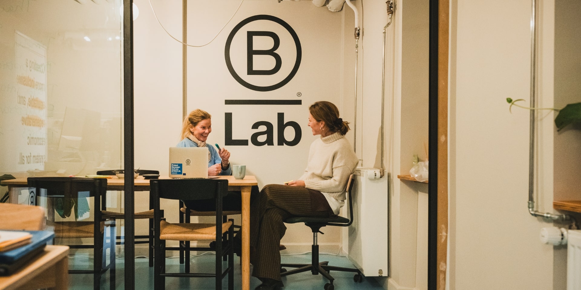 Gitte Rosholm sidder og snakker med en medarbejder